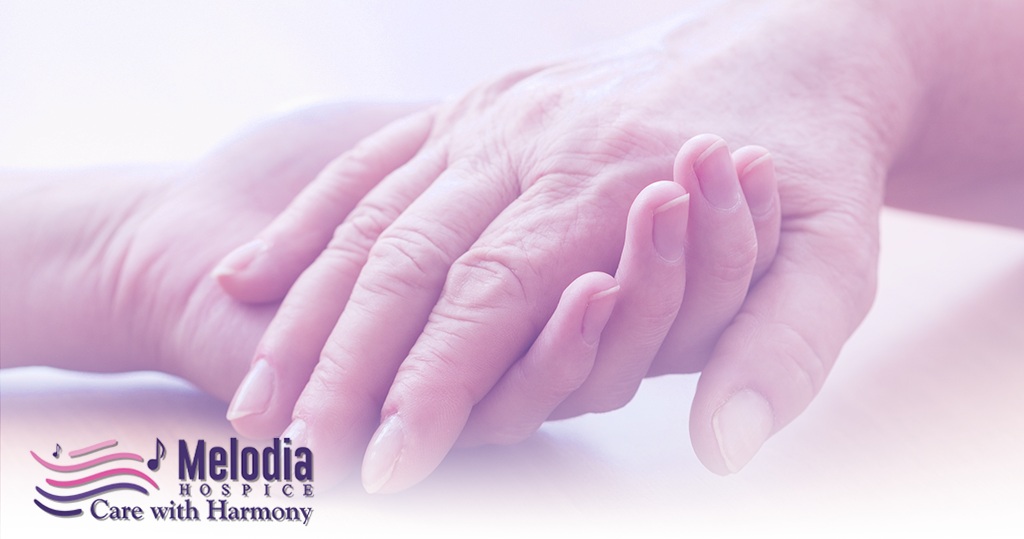 Hospice nurse holding patient hand