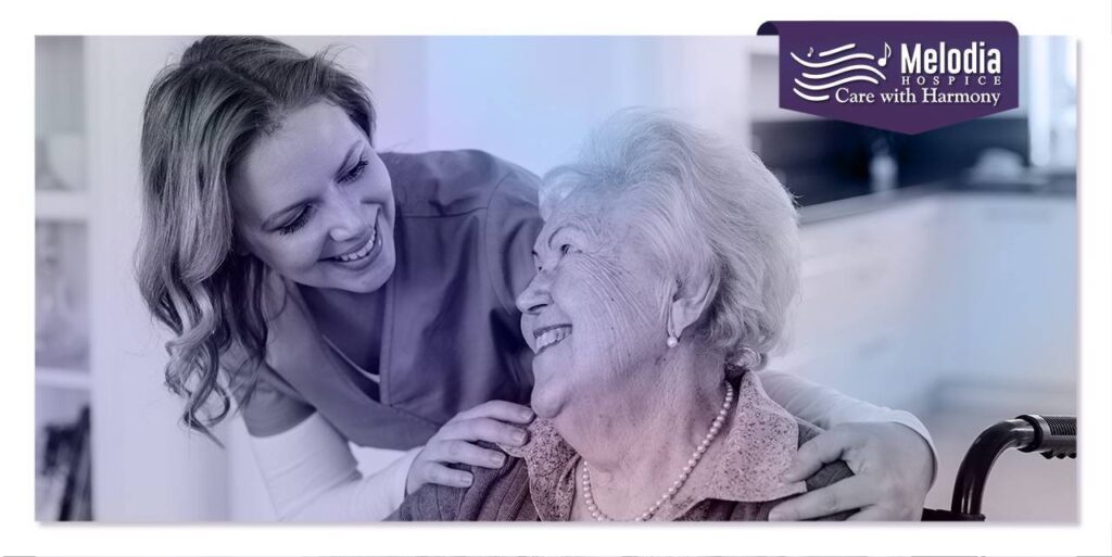 Smiling young lady caregiver providing compassionate support to her elderly hospice patient, illustrating the importance of choosing hospice care for end-of-life needs.