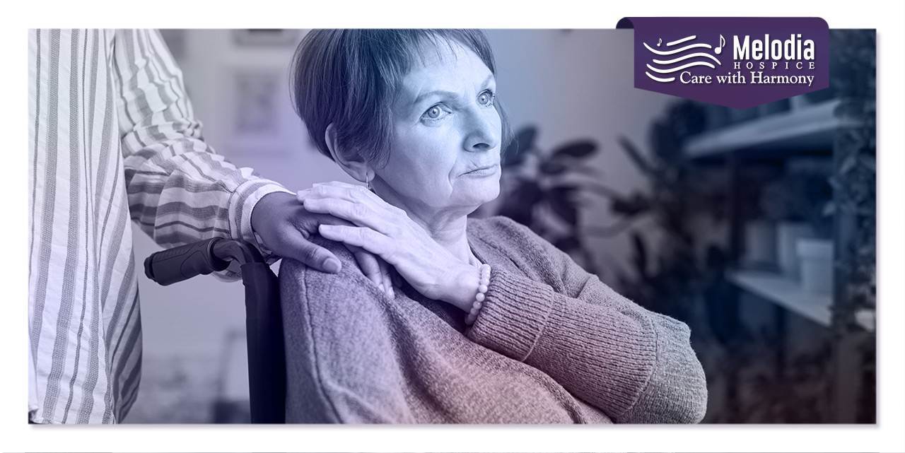 Hospice patient on wheelchair with family member's hand on shoulder, depicting what Hospice Respite Care is.