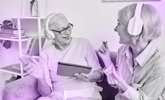 Young woman providing music therapy to elderly woman in hospice care